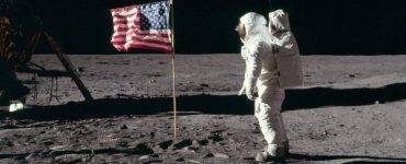 Astronaut facing flag on moon