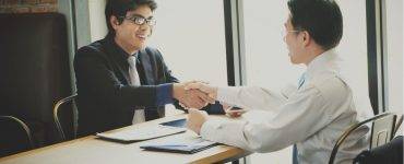 Men shaking hands across table