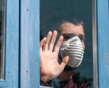 Man with mask at window