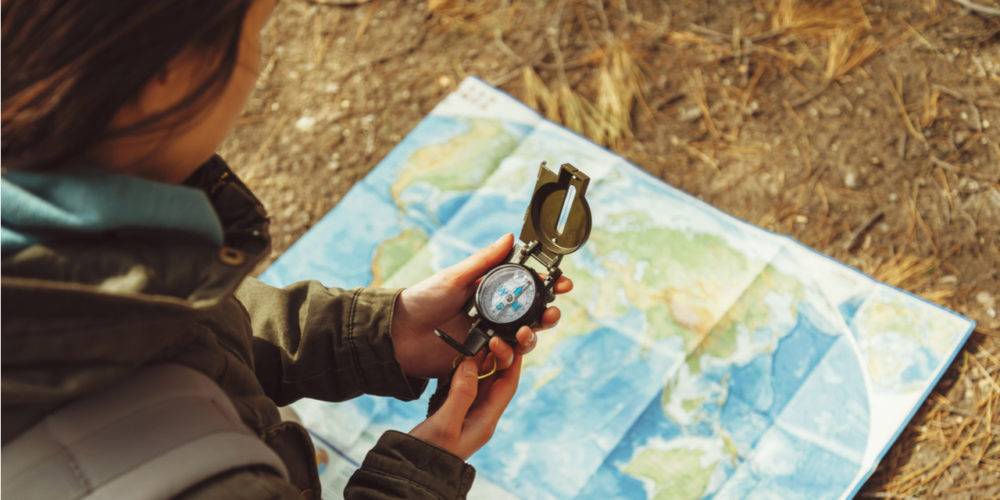 Woman using compass with map